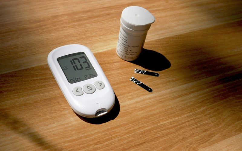 a thermometer, pills, and a bottle on a table