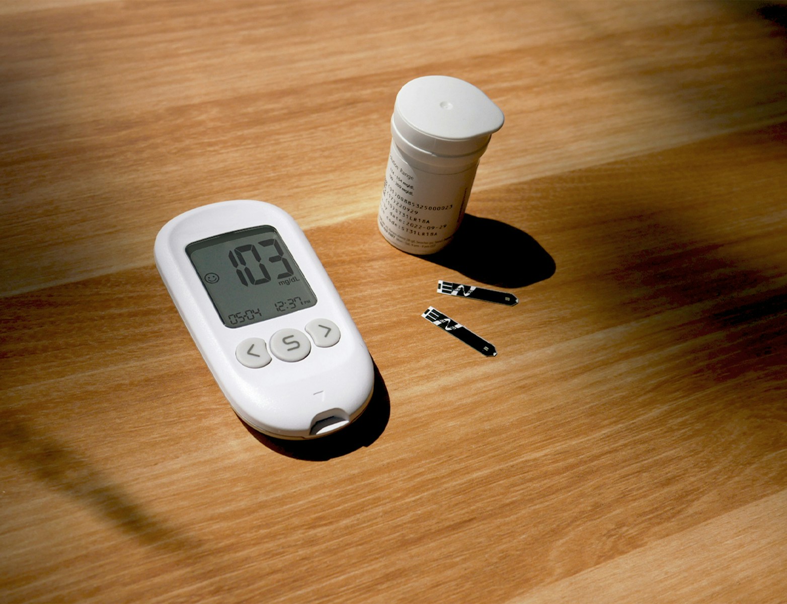 a thermometer, pills, and a bottle on a table