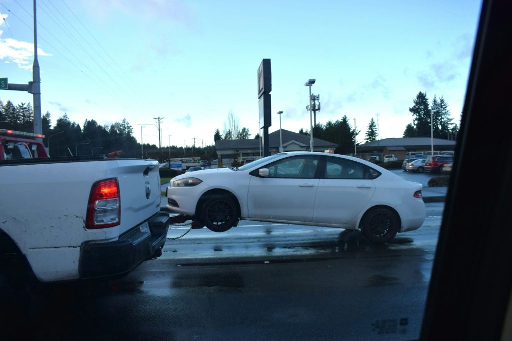 a white car being towed by a tow truck