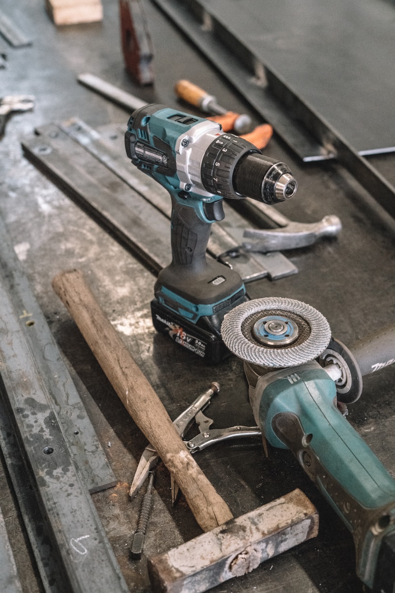 green Makita cordless drill near angle grinder