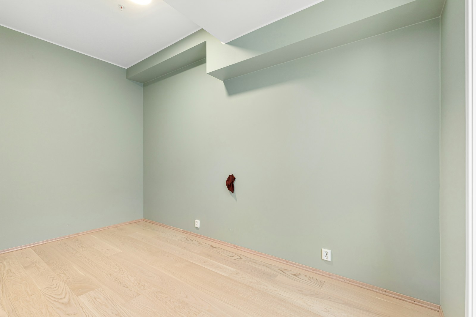 A empty room with a wooden floor and a ceiling fan